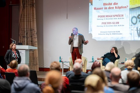 De Moderator steht und spricht