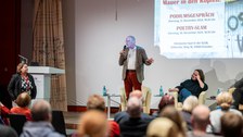 De Moderator steht und spricht