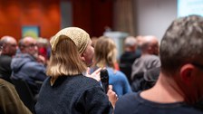 Eine junge Person aus dem Publikum spricht ins Mikrofon