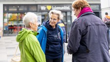 3 Personen stehen zusammen und unterhalten sich. Eine der Personen trägt einen dunkelblauen Hoodie mit der Aufschrift Technische Universität Dresden.