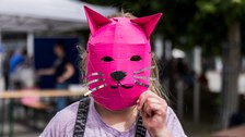 Ein Kind, das eine selbst gebastelte pinke Maske trägt.