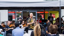 Musiker:innen spielen unter einem Pavillon. 