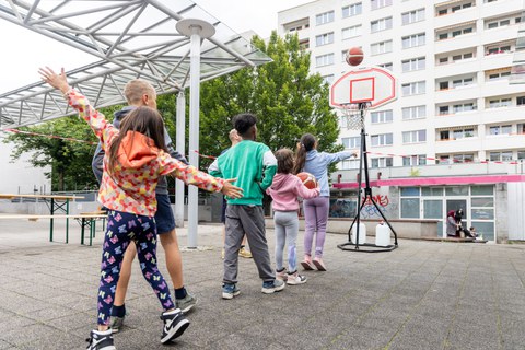 Das Foto zeigt eine Gruppe von Kindern beim Basketballspiel. 