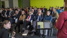 Publikum während einer musikalischen Einlage; im Vordergrund zwei Musikerinnen 