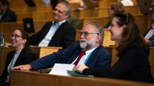 Foto von v.l.n.r.: Prof. Diana Göhringer (TUD), Prof. Martin Schulz (TUM), Prof. Wolfgang E. Nagel (TUD) und Prof. Heike Graßmann (Sächsische Staatssekretärin im SMWKT) als Zuhörende lachend im Auditorium. Im Hintergrund - verschwommen - weitere Zuhörende