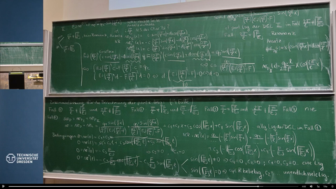 Screenshot aus der aufgezeichneten Lehrveranstaltungie, auf dem die Lösungsrechenwege der Aufgaben auf der Tafel mit Kreide angeschrieben sind.