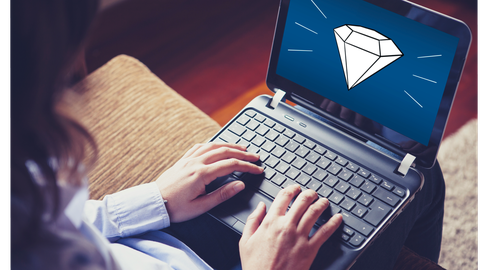 Frau mit Laptop auf dem Schoß, auf dem Display das Schmuckstück-Logo - ein Diamant