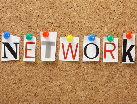 Bunte Buchstaben des Wortes Network auf einen braunen Kork-Hintergrund.