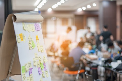 Das Bild zeigt ein Flipchart, das mit verschiedenen farbigen Haftnotizen versehen ist. 
