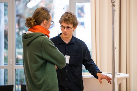 Filip Hahs erklärt einem Besucher sein Poster. 
