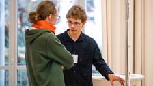 Filip Hahs erklärt einem Besucher sein Poster. 