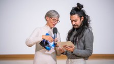Henriette Greulich und Gustavo Rosales schauen beide auf die überreichte Urkunde