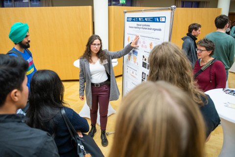 Karolin Küster erklärt interessierten Besucher:innen ihr Poster. 