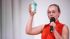 Laura Oberender präsentiert ihren Pitch und hält einen Joghurtbecher in der Hand.