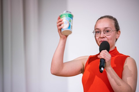 Laura Oberender präsentiert ihren Pitch und hält einen Joghurtbecher in der Hand.