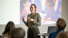 Eine Studentin hält einen Vortrag über ihre Forschung.