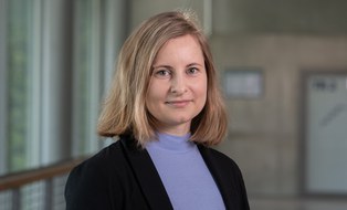 Eine Frau mit blonden schulterlangen haaren lächelt in die Kamera. 