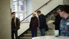Menschen stehen in einem Raum.