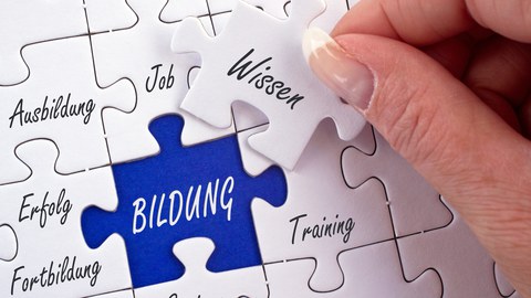 Das Foto zeigt ein weißes Puzzle. Auf einigen Puzzleteilen stehen Wörter wie beispielsweise: "Ausbildung", "Job", "Training". Im Puzzle ist eine Lücke in der das Wort "Bildung" steht. Diese Lücke wird mit dem Puzzlestück "Wissen" ausgefüllt.