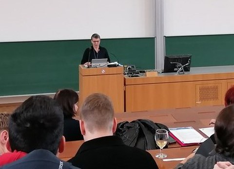 Prof. Hoffkamp steht im Hörsaal und begrüßt die Teilnehmenden