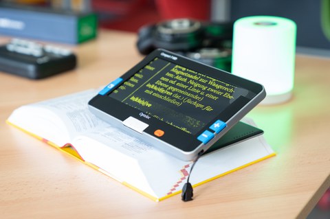 Lesehilfe zur Vergrößerung von Text liegt auf Duden