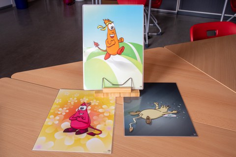 Comic-Figuren, die bestimmte Gefühle ausdrücken. Ausgedruckt, laminiert und liegend auf einem Tisch.