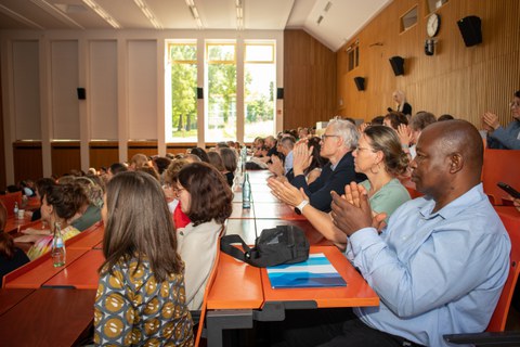Personen sitzen im Hörsaal und klatschen