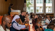 Personen sitzen im Hörsaal