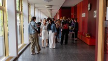 Viele Personen stehen im Gang eines Unigebäudes