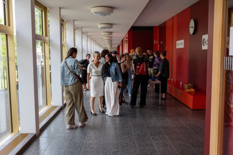 Viele Personen stehen im Gang eines Unigebäudes