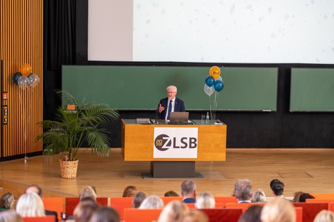 Mann hält Vortrag und steht an einem Pult