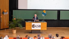 Mann hält Vortrag und steht an einem Pult