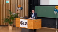 Mann hält Vortrag und steht an einem Pult