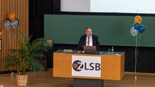 Mann hält Vortrag und steht an einem Pult