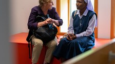 Zwei Frauen sitzen nebeneinander und unterhalten sich
