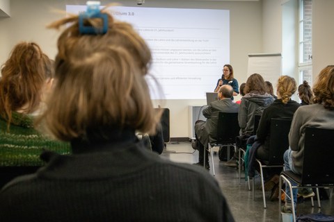 Foto zeigt einen Saal mit einer Frau, die einen Vortrag hält.