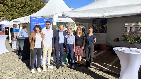 Gruppenbild mit 6 Personen vor Veranstaltungszelten