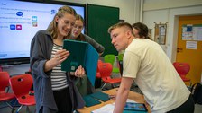 kleine Gruppe junger Menschen sieht zusammen in ein Tablet