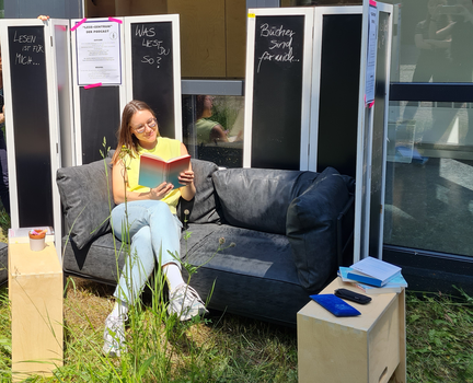Frau sitzt auf Sofa und liest Buch
