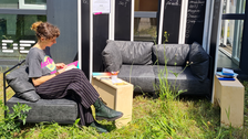 Frau sitzt auf Sofa und liest Buch