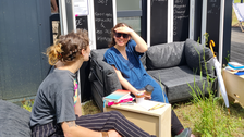 Zwei Frauen sitzen auf Sofa und unterhalten sich