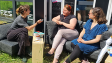 Drei Frauen sitzen auf Sofa und unterhalten sich