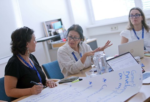 Drei Frauen im Gespräch an einem Tisch