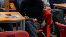 Frau notiert etwas während eines Vortrags