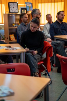 Frau notiert etwas während eines Vortrags
