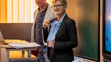 Frau hält Vortrag und steht an einem Pult.