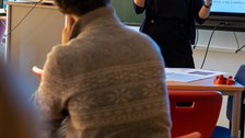 Frau hält Vortrag vor einer interaktiven Tafel