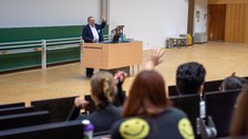 Mann hält Vortrag in einem Hörsaal an einem Rednerpult.