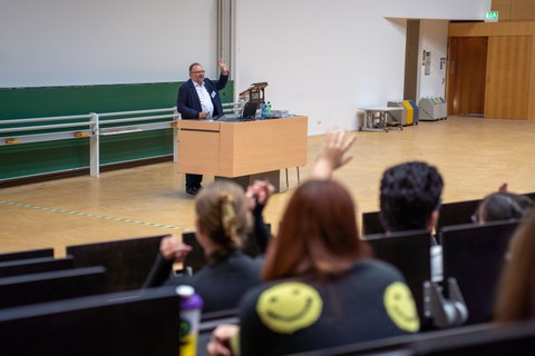 Mann hält Vortrag in einem Hörsaal an einem Rednerpult.