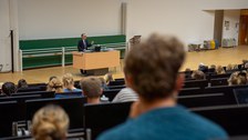 Mann hält Vortrag in einem Hörsaal an einem Rednerpult.